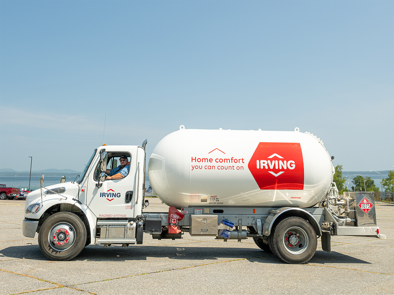 A picture of a propane truck facing to the left side on a clear sunny day.