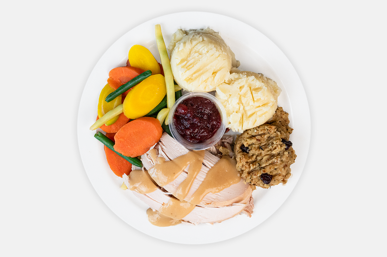 A picture of Turkey dinner with mashed potato and vegetables