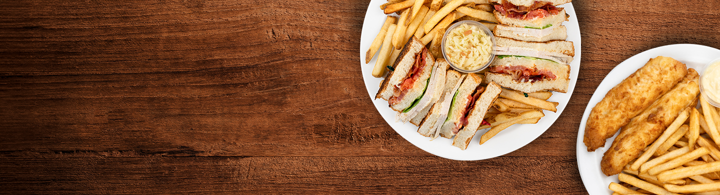 Club sandwich and fish and chips served with fries and coleslaw.