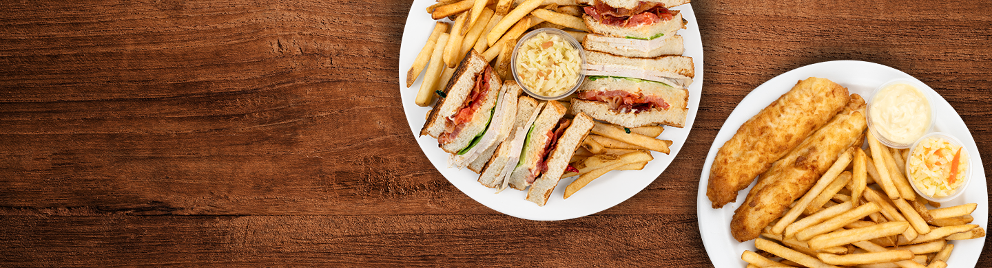 Club sandwich and fish and chips served with fries and coleslaw.