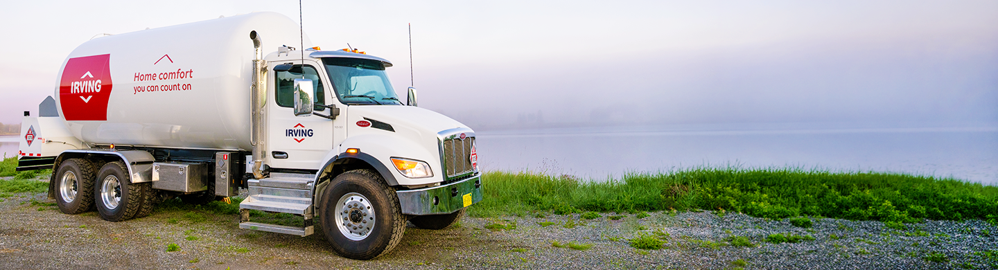 Irving fuel delivery truck parked beside a coastal roadway overlooking the water.