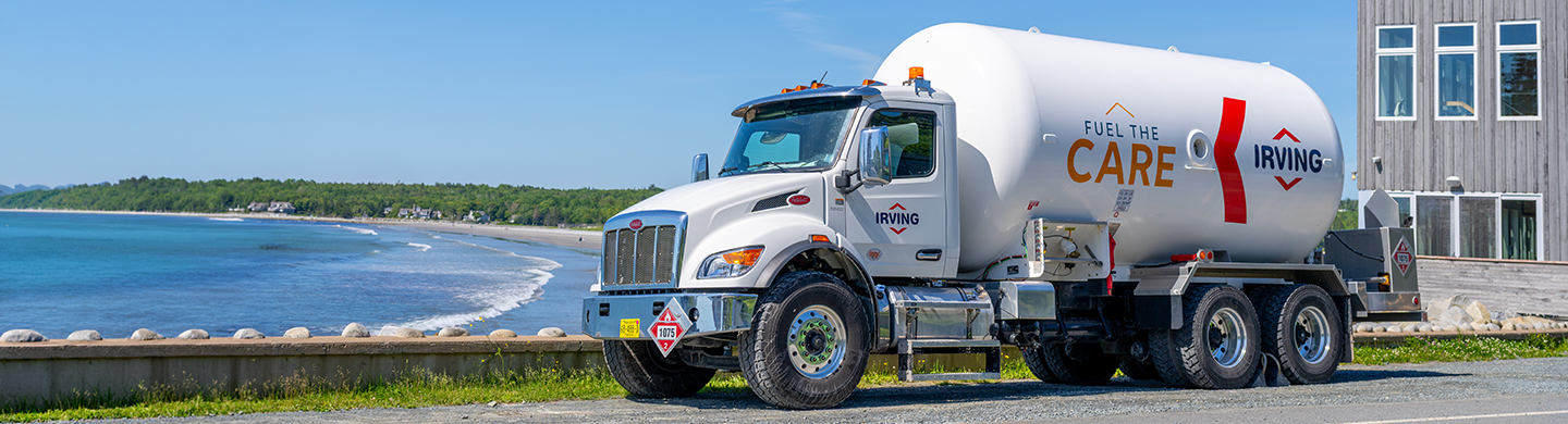 Irving fuel delivery truck parked beside a coastal roadway overlooking the water.