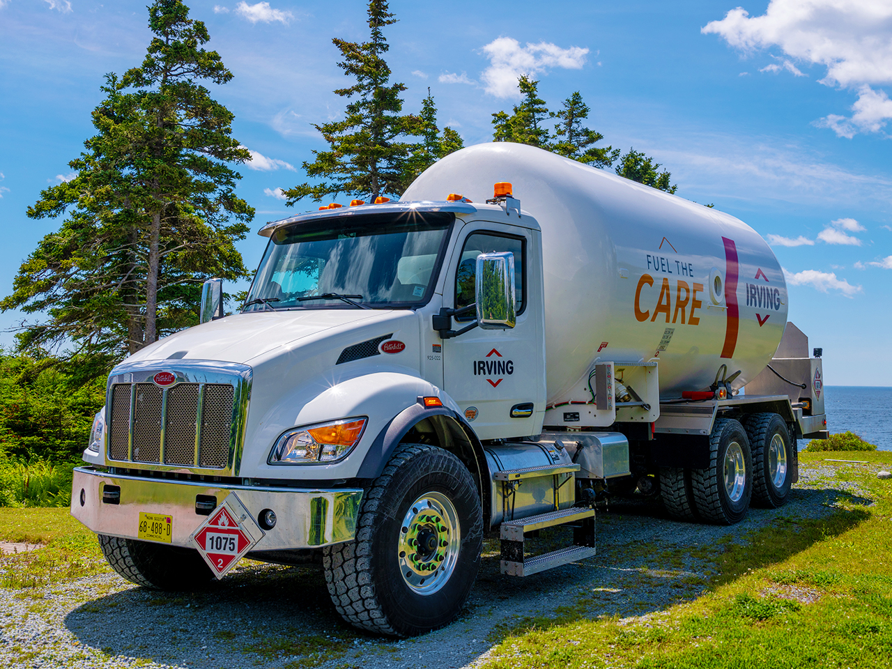Irving fuel delivery truck parked beside a coastal roadway overlooking the water.