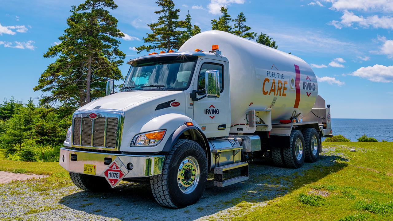 Irving fuel delivery truck parked beside a coastal roadway overlooking the water.