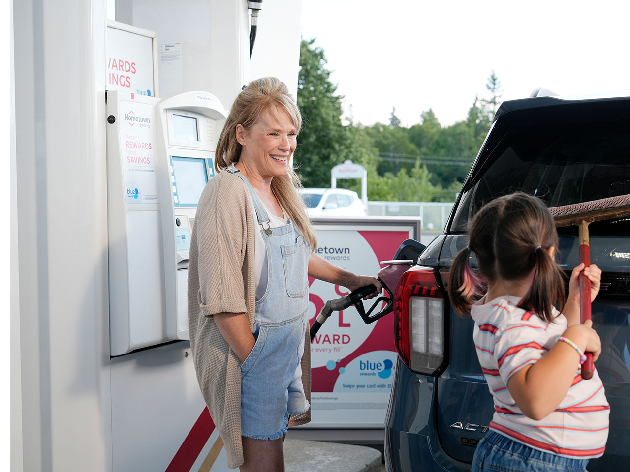 A picture of a mom and a child at one of the Irving's gas pumps.