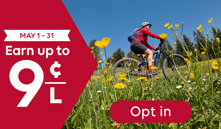 Promotional offer: “May 1–31. Earn up to 9 cents per litre.” Image shows a cyclist riding a mountain bike through a grassy field with yellow flowers. A button reads “Opt in.”
