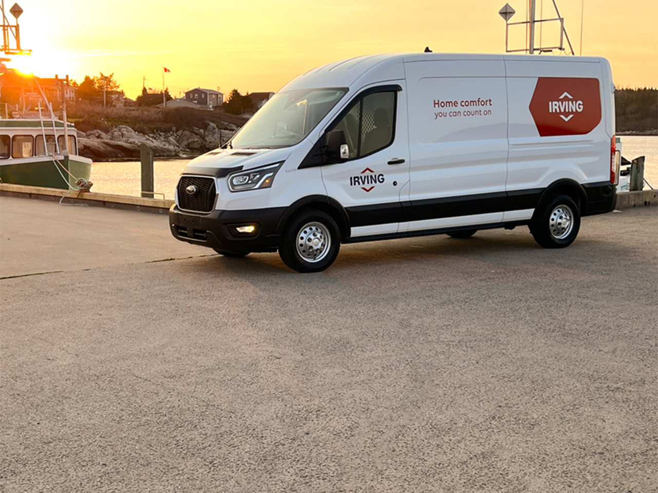 Irving service van parked at a waterfront dock at sunset, with a fishing boat moored nearby and the text “Home comfort you can count on” displayed on the van.